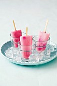 Milk ice lollies on sticks with rose petals and strawberry liqueur