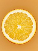 A slice of orange on orange surface, close-up