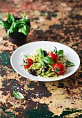 Spaghetti with pesto, tomatoes and olives