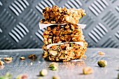 A stack of muesli bars with pistachio nuts and flaxseeds