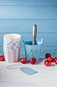 Cherries with paper cups and an ice cream scoop