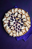 A whole blackberry and almond tart decorated with pastry leaves (seen from above)