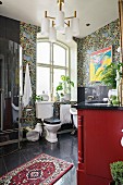 Vintage Badezimmer mit Toilette vor Fenster, orientalischer Teppichläufer auf schwarzem Fliesenboden