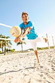 Junger Mann beim Beach-Volleyball