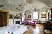 Schlafbereich mit pinkfarbenen Sesseln in eleganter, antiker Villa mit Freskenmalereien
