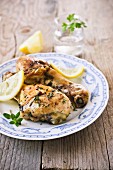 Grilled chicken legs with fresh herbs and lemons