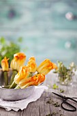 Courgette flowers in a metal bowl