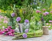 Green asparagus and fresh herbs on a garden table