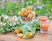 Physalis and fruit juice on a garden table