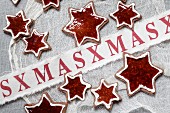 Sternförmige Mandelplätzchen mit Johannisbeergelee-Füllung und weihnachtlicher Dekoration