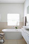 Free-standing bathtub in bright bathroom