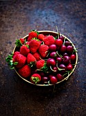 A bowl of fresh cherries and strawberries
