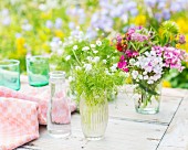Dill and summer flowers in glass vases