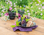 Purple figs on a pewter plate on a garden table