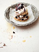 A stack of pancakes with blueberries and cream