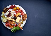 Cheese platter with fruit, vegetables and meats