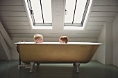 Zwei Kinder sitzen in der Badewanne