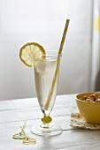 A Hugo cocktail with a straw and a slice of lemon