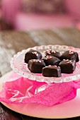 Chocolate pralines with sugar hearts on a crystal plate