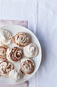 Meringues with and without chocolate swirls on a plate