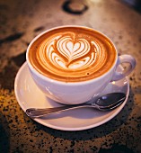A cappuccino with a heart design in the milk from