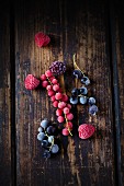 Frozen redcurrants, blackcurrants, raspberries and blackberries on a wooden surface