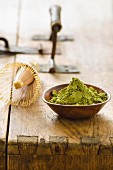 An arrangement of matcha powder and a tea whisk on a wooden table