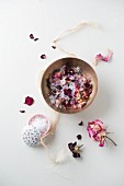 A bowl of bathing salts and dried rose petals