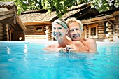 A happy older couple in a swimming pool at a spa