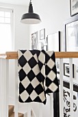 A hand-knitted black and white checked blanket made of Merino yarn