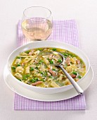 Noodle soup with peas and strips of ham