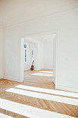 Guitar leaning against wall in empty room