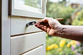 Hand of man painting a door