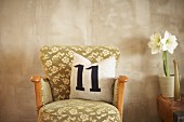 Kissen mit Zahl 11 auf einem Vintage-Sessel