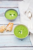 Cream of wild garlic soup in bowls with bread