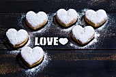 The word Love stencilled with icing sugar and surrounded by heart-shaped doughnuts