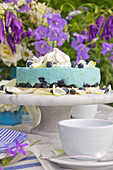 Blueberry mousse tart in front of vase of bellflowers