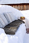 Winter picnic on bench carved out of snow