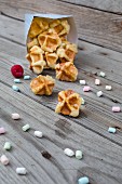 Waffle bites in a paper bag with mini marshmallows in front of it