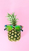 A pineapple wearing colourful sunglasses