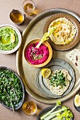Various types of hummus with lettuce and unleavened bread