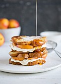 Honey being drizzled over a stack of French toast with cream cheese and apricots