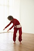 Turning the hoop (qigong) – Step 6: bend to the left, arms down