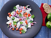 White fish ceviche with red onions and diced tomatoes