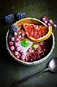 A smoothie bowl with wholemeal oats, coconuts, chia seeds, grapefruit and frozen berries