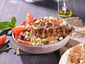 Couscous tabbouleh with meat kebabs and pitta bread