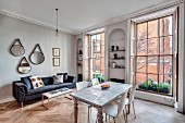Offener Wohnraum mit Esstisch und Sofa in renovierter Stadtwohnung