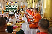 Sitzende Mönche bei einer Zeremonie im buddhistischen Tempel Wat Ong Teu, Vientiane, Laos