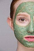 Junge Frau mit grüner Gesichtsmaske