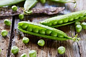 Pea pods on a wooden surface